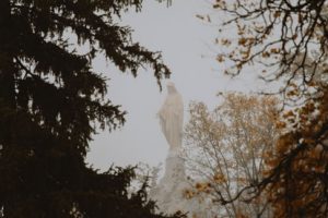 A statue of the virgin mary in the fog.