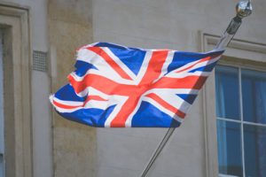 A british flag flies in front of a building.