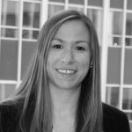 A black and white photo of a woman smiling.