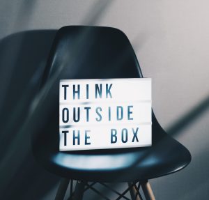 A black chair with a sign that says think outside the box.