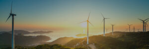 Wind turbines on a hill overlooking the ocean, showcasing fundraising and CSR thought leadership.